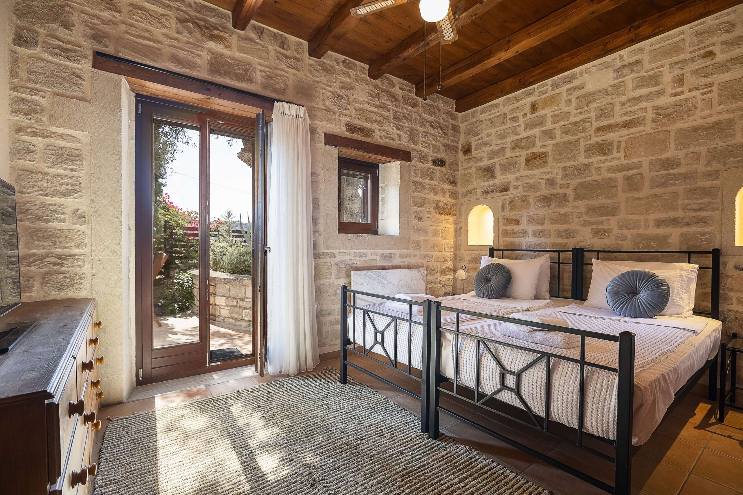 Air-conditioned bedroom with stone walls at Oia Residence holiday villa Rethymno