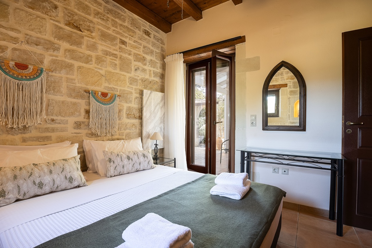 Spacious master bedroom with mountain views at Oia Residence private villa Erfoi Crete