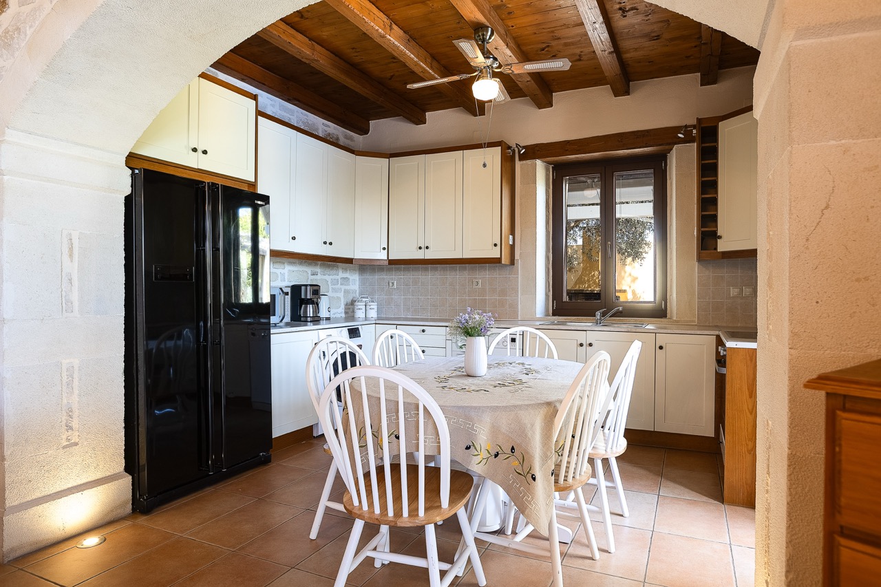 Fully equipped stone kitchen with dining area at Oia Residence villa in Crete
